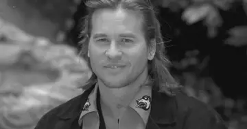 Val Kilmer, znany z wielu filmów, z charakterystycznym uśmiechem i długimi włosami.