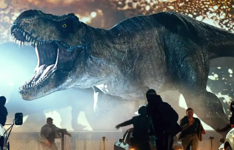 Gigantyczny Tyranozaur Rex z Jurassic World 3 z otwartą paszczą ściga ludzi wśród samochodów.